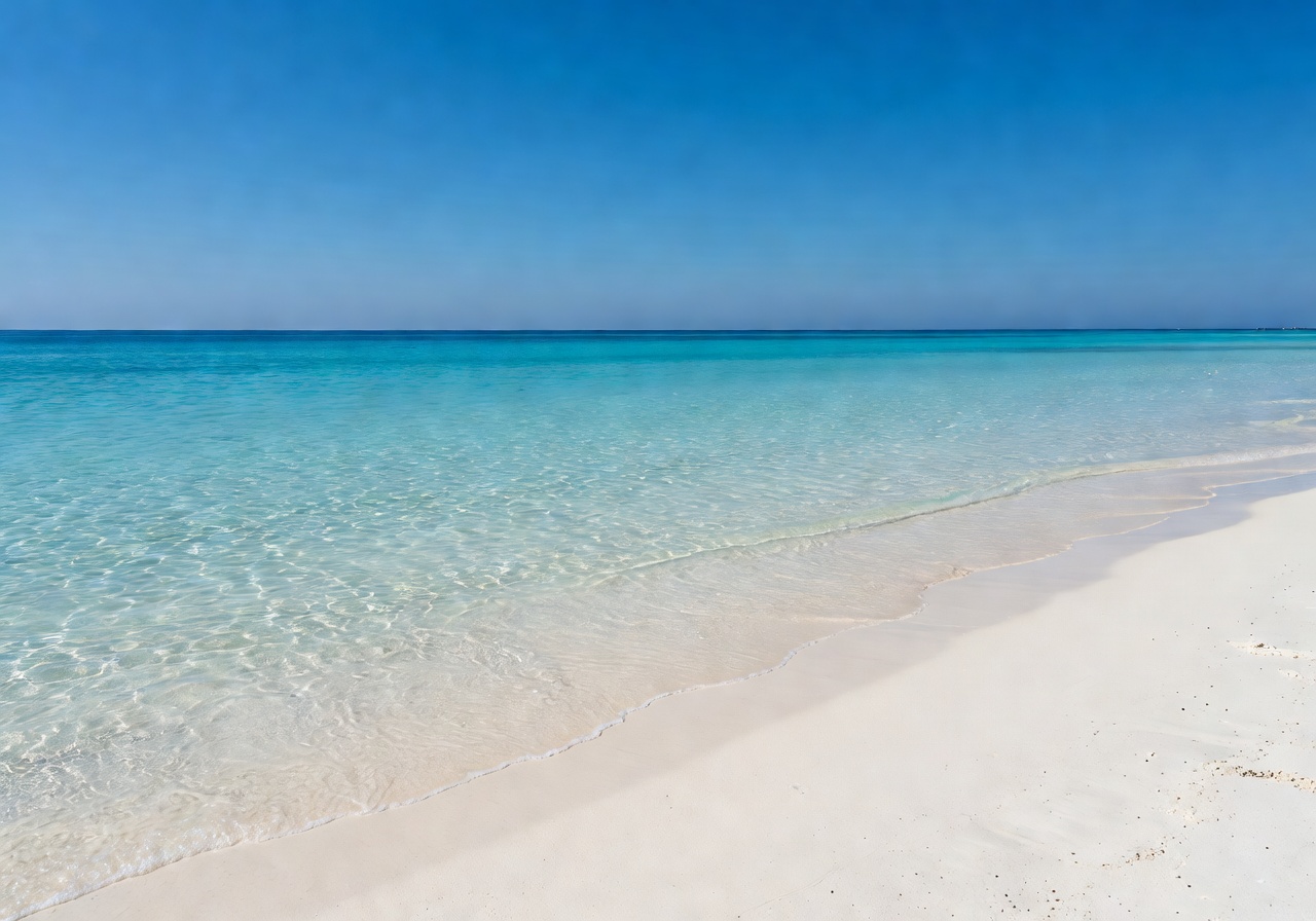Crystal clear shallow water at a Mediterranean beach with white sand and blue sky